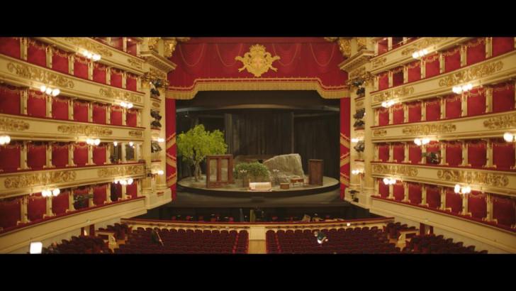 Photo prise depuis les balcons, face à la scène sur laquelle est installé le décor. La salle est vide.